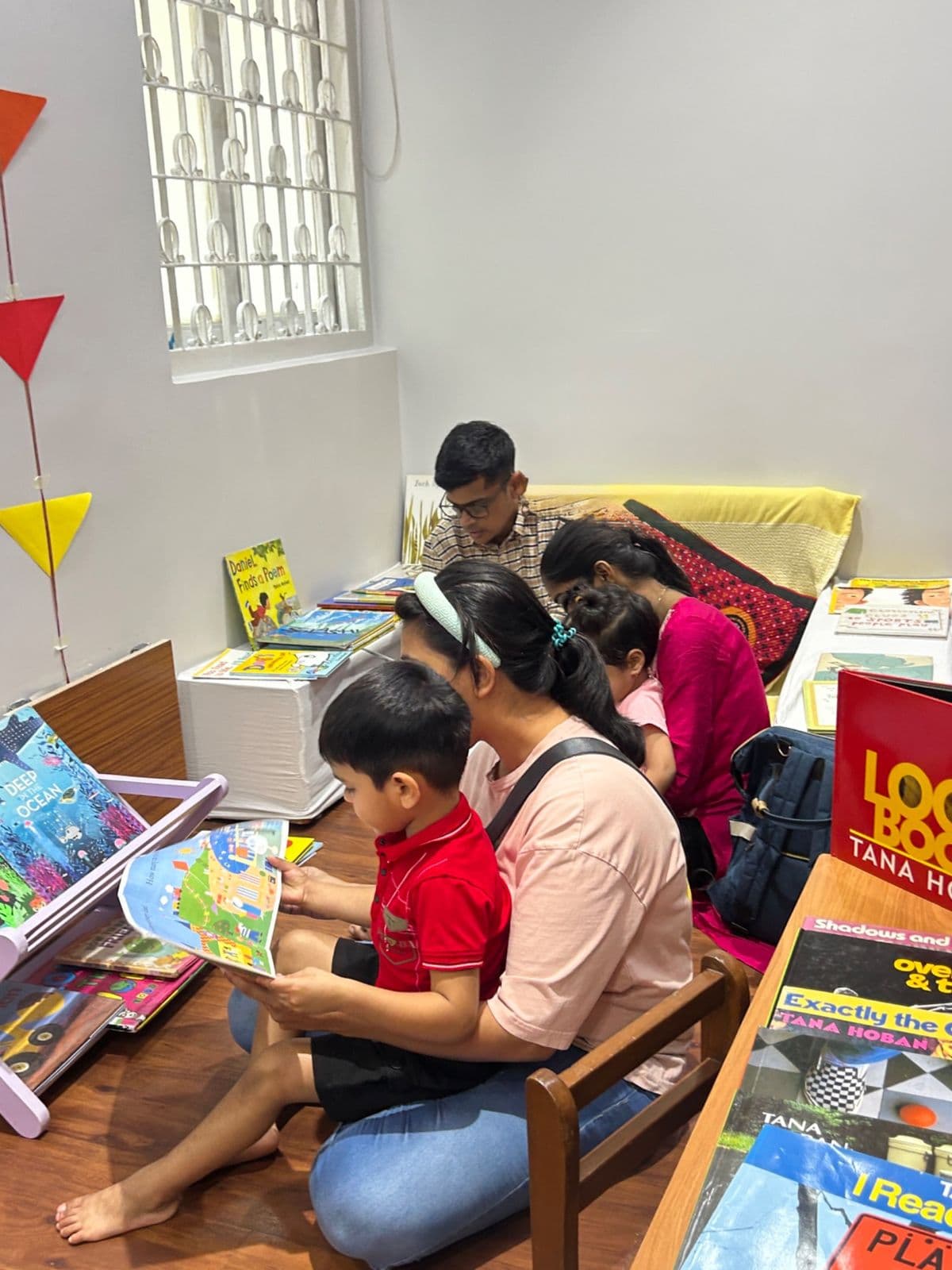Families browsing and reading in a sunny corner of the Lightship reading room